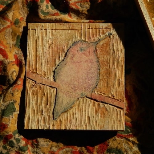 A carved mokuhanga block of a hummingbird
